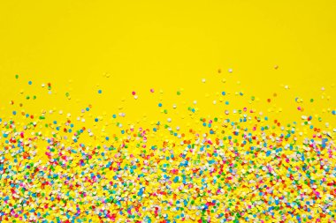 Turuncu arka plan önünde renkli konfeti. 