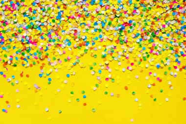 Turuncu arka plan önünde renkli konfeti. 