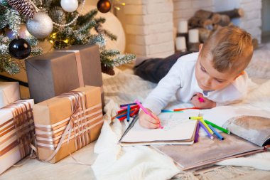 Çocuk albüm işaretçileri bir Noel yeşil ağaç çizer.