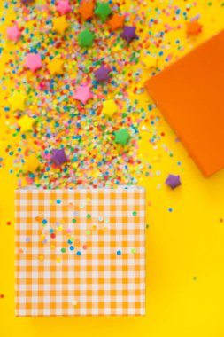 Yellow background. A box with accessories for a birthday, a party or a new year.