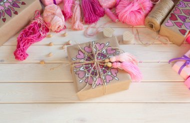 Pembe püsküllü. Beyaz ahşap arka plan. Kadın el sanatları. Yaratıcılık kavramı.