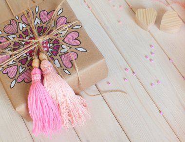 Pembe püsküllü. Beyaz ahşap arka plan. Kadın el sanatları. Yaratıcılık kavramı.