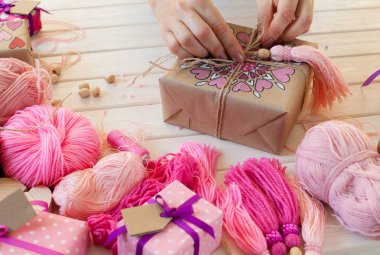 Pembe püsküllü. Beyaz ahşap arka plan. Kadın el sanatları. Yaratıcılık kavramı.