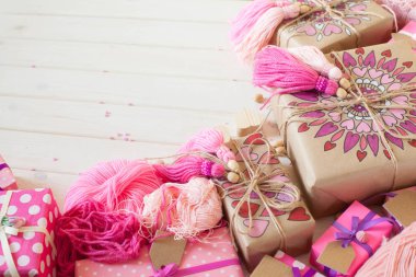 Pembe püsküllü. Beyaz ahşap arka plan. Kadın el sanatları. Yaratıcılık kavramı.