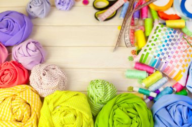 Dikiş aksesuarları beyaz bir arka plan üzerinde yalan. Ölçüm bandı, iplik, kumaş, İğne mili ve iğneler dikiş için.