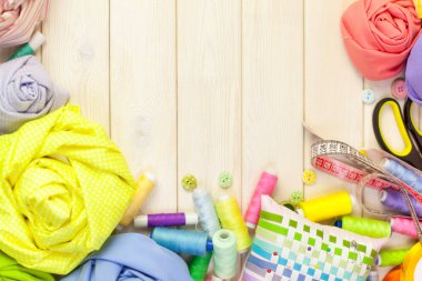 Dikiş aksesuarları beyaz bir arka plan üzerinde yalan. Ölçüm bandı, iplik, kumaş, İğne mili ve iğneler dikiş için.