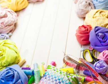 Dikiş aksesuarları beyaz bir arka plan üzerinde yalan. Ölçüm bandı, iplik, kumaş, İğne mili ve iğneler dikiş için.