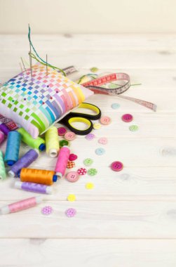 Dikiş aksesuarları beyaz bir arka plan üzerinde yalan. Ölçüm bandı, iplik, kumaş, İğne mili ve iğneler dikiş için.