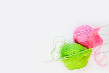 Örme kumaş yeşil ve pembe. Yeşil ve pembe örgü iplik. Beyaz arka plan.