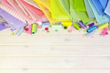 Dikiş aksesuarları beyaz bir arka plan üzerinde yalan. Ölçüm bandı, iplik, kumaş, İğne mili ve iğneler dikiş için.