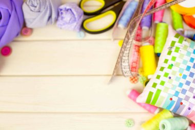 Dikiş aksesuarları beyaz bir arka plan üzerinde yalan. Ölçüm bandı, iplik, kumaş, İğne mili ve iğneler dikiş için.