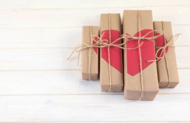 Hediye kutusu yürekleri. Kraft kağıt. Arka plan beyaz ahşap.