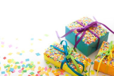 Renkli kurdeleler ve konfeti ile renkli hediye kutuları. Beyaz arka plan. Noel veya Doğum günü için hediyeler