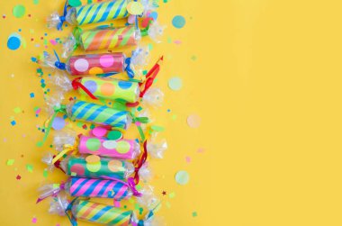 Sarı bir arka planda konfeti ile kutlama kraker