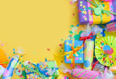 Sarı bir arka planda konfeti ve parlak hediyeler ile kutlama kraker.