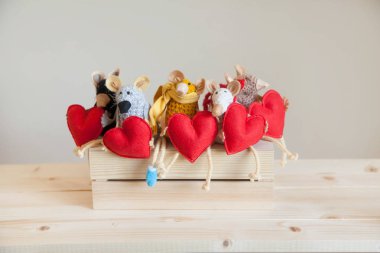 Örme fare oyuncakları kırmızı kalpler tutun.