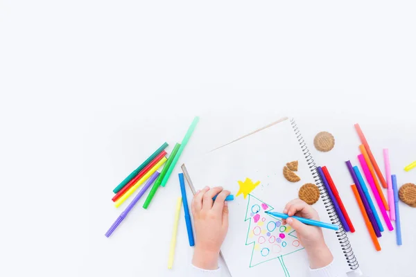 Дитина малює ялинку з кольоровими олівцями і маркером — стокове фото