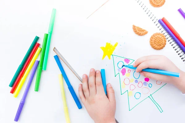 Çocuk renkli kalem ve marker ile bir Noel ağacı çizer — Stok fotoğraf