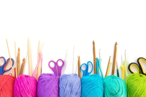 Colorful rainbow yarn for knitting. Hooks, scissors and knitting needles.