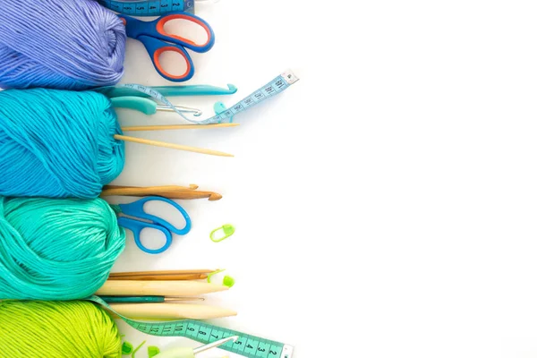 Colorful rainbow yarn for knitting. Hooks, scissors and knitting needles.