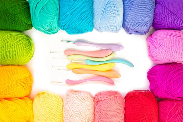 Colorful rainbow yarn for knitting. Hooks, scissors and knitting needles.