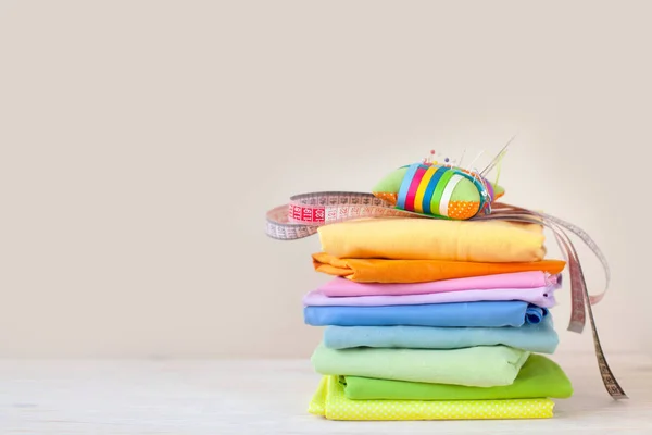 Pilha Dobrada Tecido Colorido Cama Agulha Tesoura Fita Métrica Fundo — Fotografia de Stock