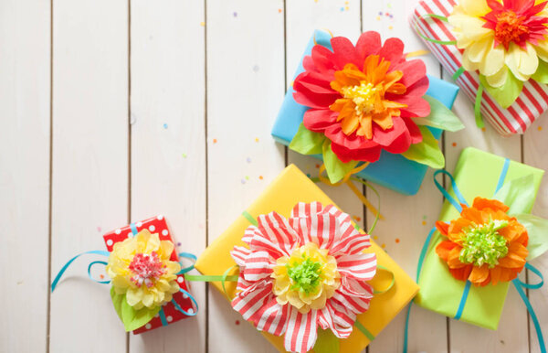 Flowers made of paper. White wood background.