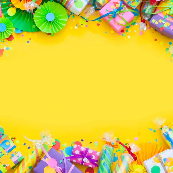 庆祝饼干与五彩纸屑和明亮的礼物在黄色背景 — 图库照片