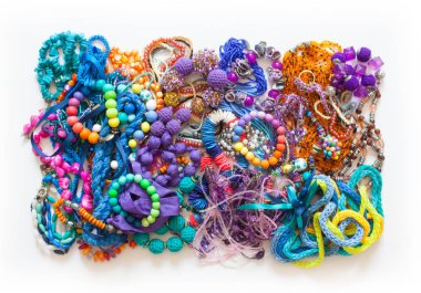 Beyaz bir arka planda renkli boncuk, penye ve Bijuteri yalan.