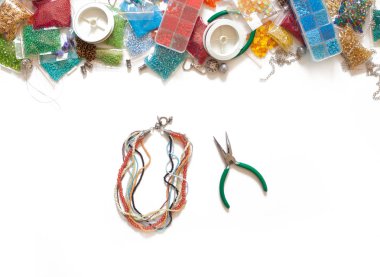 Beyaz bir arka planda renkli boncuk, penye ve Bijuteri yalan.