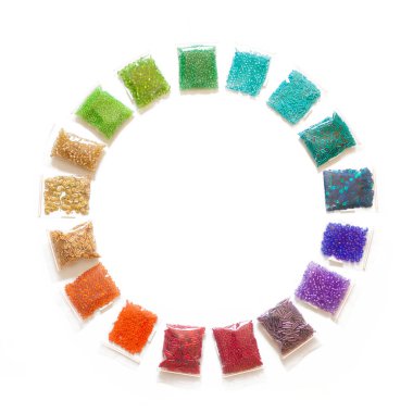 Beyaz bir arka planda renkli boncuk, penye ve Bijuteri yalan.