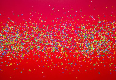 Çerçeve renkli konfeti yaptı. Kırmızı bir arka plan. 