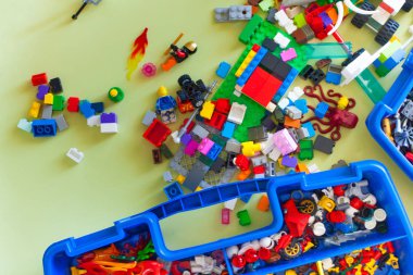 Küçük sarışın çocuk çocuk renkli plastik blok kapalı birçok ile oyun. Lego blokları sıralanır. Lego klasik depolama.
