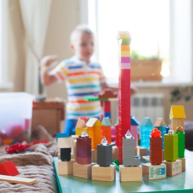 Küçük sarışın çocuk çocuk renkli plastik blok kapalı birçok ile oyun. Lego Duplo