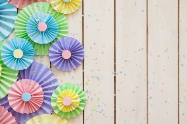 Renkli parlak pastel kağıt rozet. Dekorasyon için bir parti. Beyaz tahta arka plan