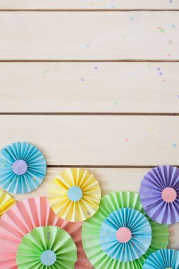 Renkli parlak pastel kağıt rozet. Dekorasyon için bir parti. Beyaz tahta arka plan