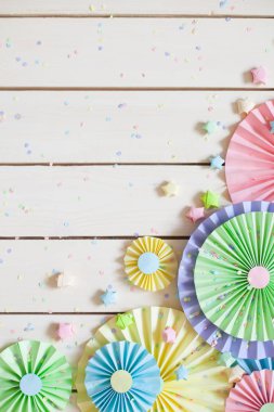 Renkli parlak pastel kağıt rozet. Dekorasyon için bir parti. Beyaz tahta arka plan