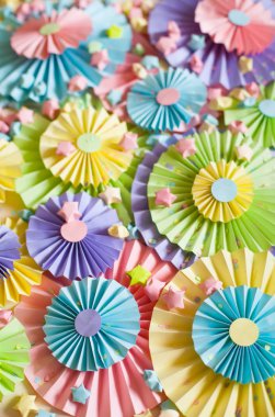 Renkli parlak pastel kağıt rozet. Dekorasyon için bir parti. Beyaz tahta arka plan