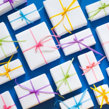 Mavi arka plan. Birçok hediyeler farklı boyutlarda. Beyaz hediye kutuları.