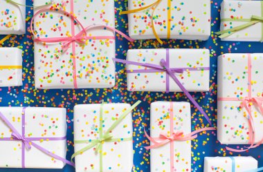 Mavi arka plan. Birçok hediyeler farklı boyutlarda. Beyaz hediye kutuları.