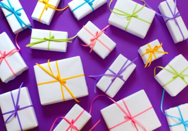 Lila arka plan. Birçok hediyeler farklı boyutlarda. Beyaz hediye kutuları. 