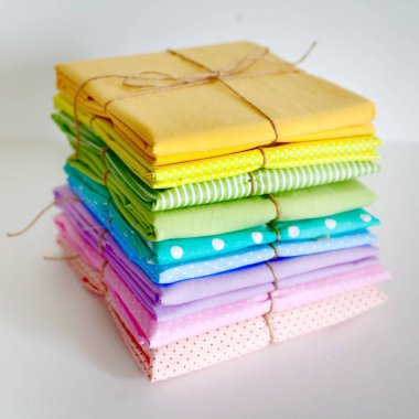 Dikiş için malzemeler. Renkli kumaş, iplik ve beyaz bir arka plan üzerinde düğmeleri. Renkli iğne iğne Yataklı.