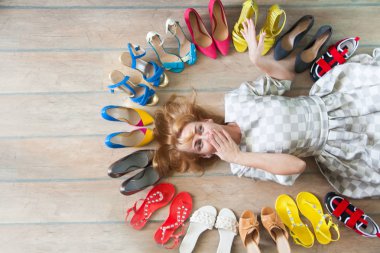Woman choosing shoes. Colored shoes are exposed in a circle. clipart