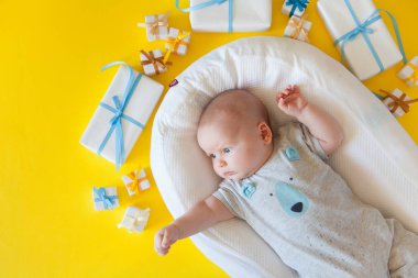 Bebek giyim, banyo malzemeleri, oyuncaklar ve sağlık bakım aksesuarları ile sarı arka plan üzerinde. Liste veya genel bilgileri hamilelik ve bebek duş alışveriş diliyorum. Yukarıdan görüntüleyin. Çocuk besleme değiştirme ve banyo