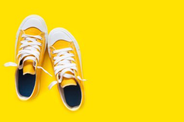 Sarı bir arka plan üzerinde kısa düşük parlak spor ayakkabı.