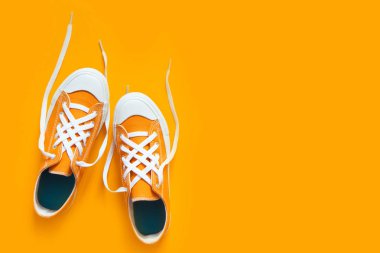 Turuncu bir arka plan üzerinde kısa düşük parlak spor ayakkabı. 
