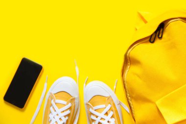 Sarı bir arka plan üzerinde kısa düşük parlak spor ayakkabı.