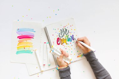 grafik tasarım, el yazısı, yaratma kavramı. ihale küçük elleri kadın ressam süs süslü harfler beyaz çizgili kağıt üzerinde keçeli kalemler ile inscribing.