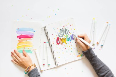 grafik tasarım, el yazısı, yaratma kavramı. ihale küçük elleri kadın ressam süs süslü harfler beyaz çizgili kağıt üzerinde keçeli kalemler ile inscribing.