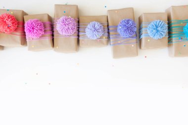 Renkli kurdeleler ve ponpon ile renkli hediye kutuları. Beyaz backg